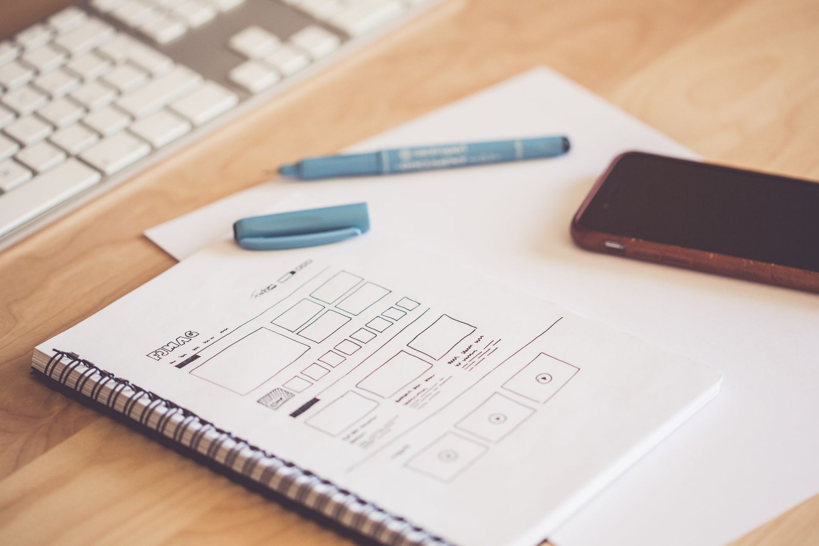 Web & UX/UI Design Colourful interface mockups laid out on a desk